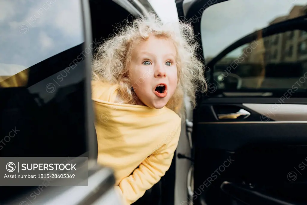 Excited girl leaning out of car