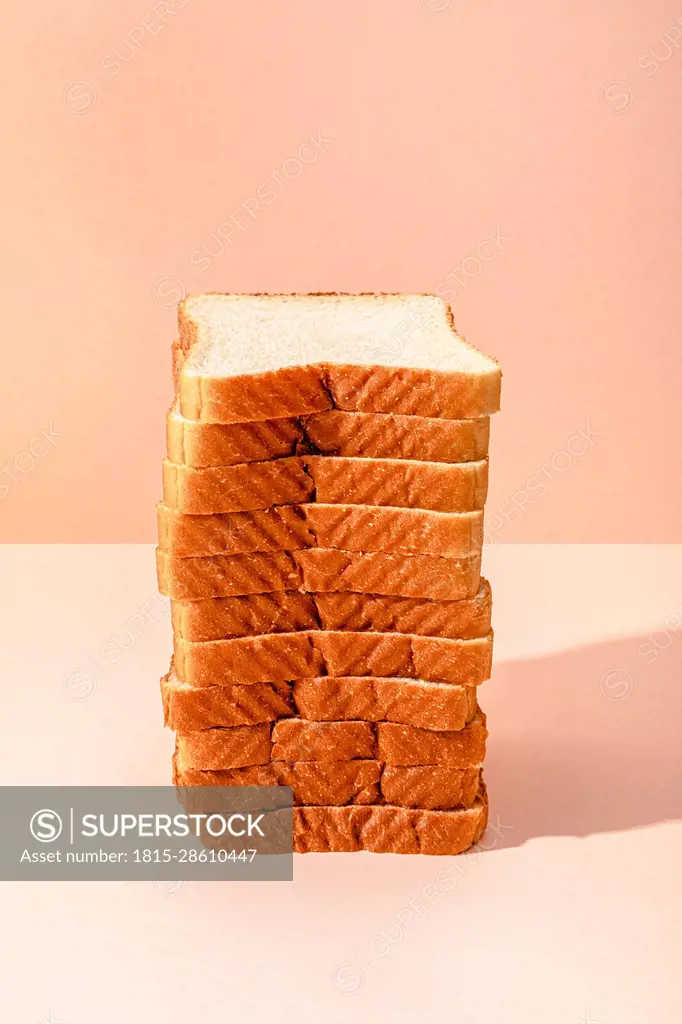 Stack of bread slices over peach background