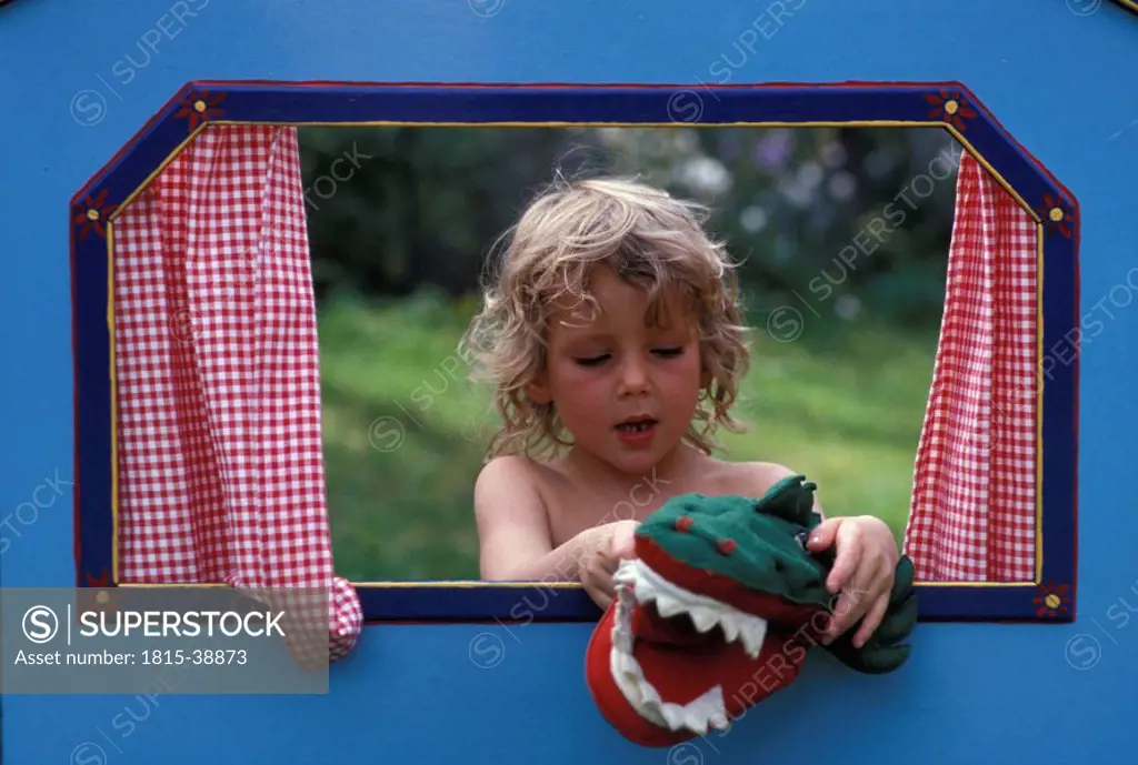 Girl playing with crocodile hand puppet