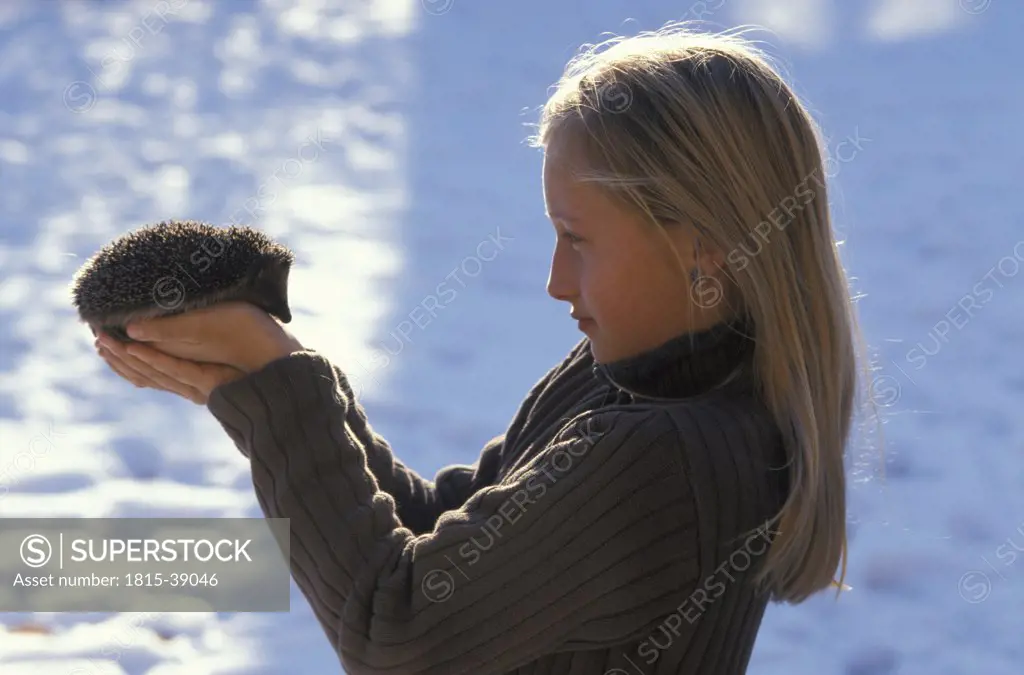 Girl holding hedgehog, portrait
