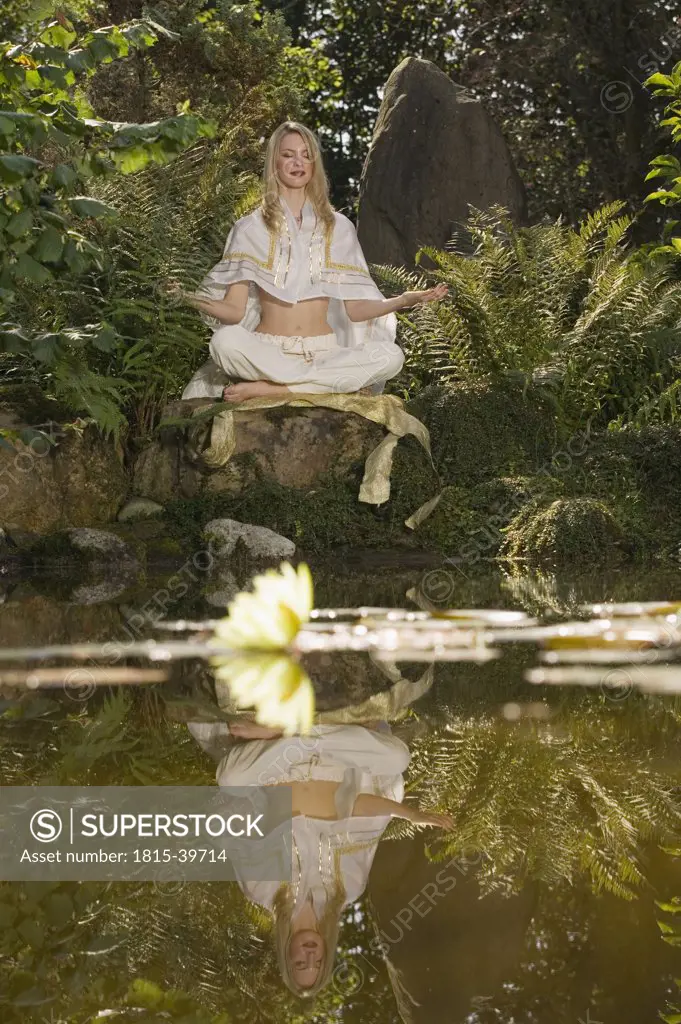 Young woman meditating, outdoors