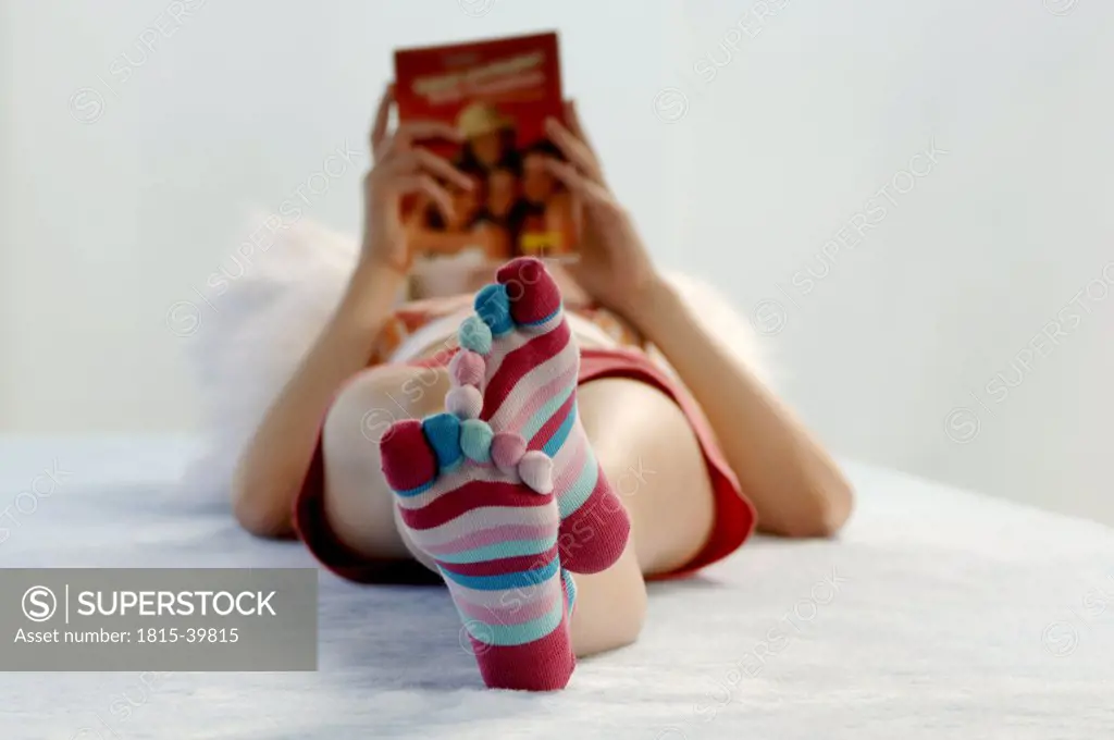 Girl with striped socks laying on bed