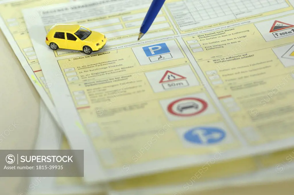 Pen and toy car on driving licence test form