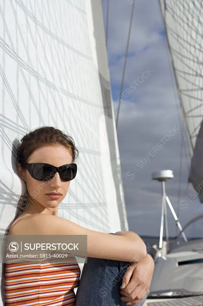 Germany, Baltic Sea, Lübecker Bucht, Young woman sitting on deck of yacht, portrait