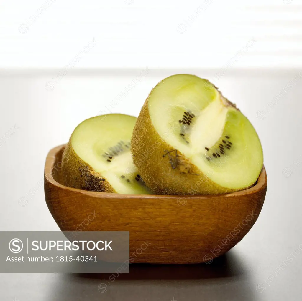 Kiwi halves in wooden bowl, close-up