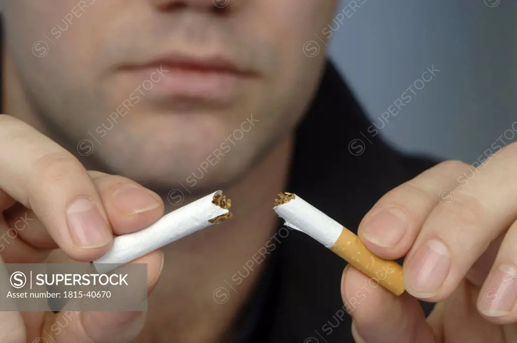 Man breaking up cigarette