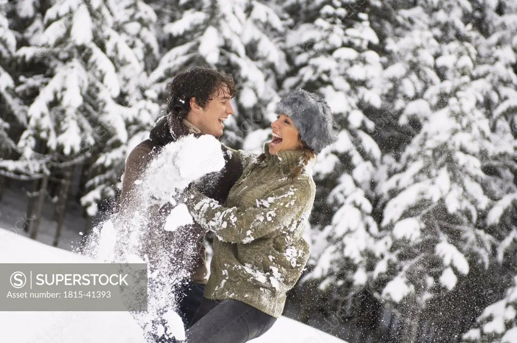Austria, Salzburger Land, Altenmarkt, Young couple in snowscape, fooling around