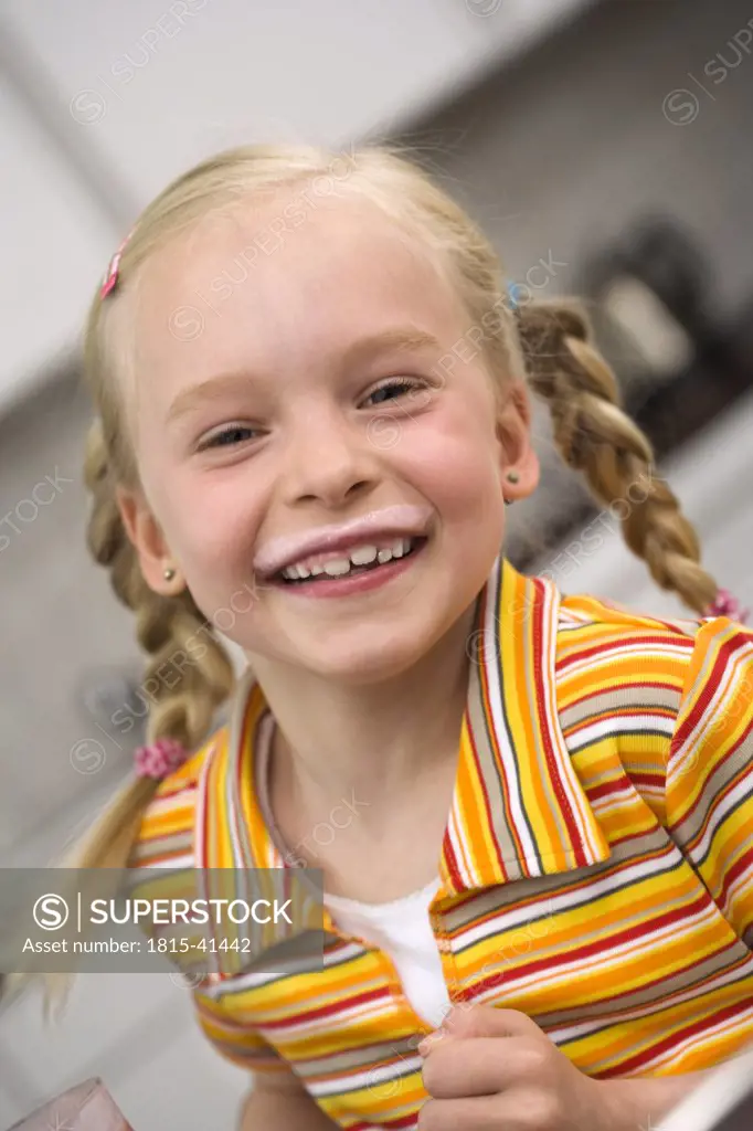 Young girl (10-11) with a milk moustache, portrait