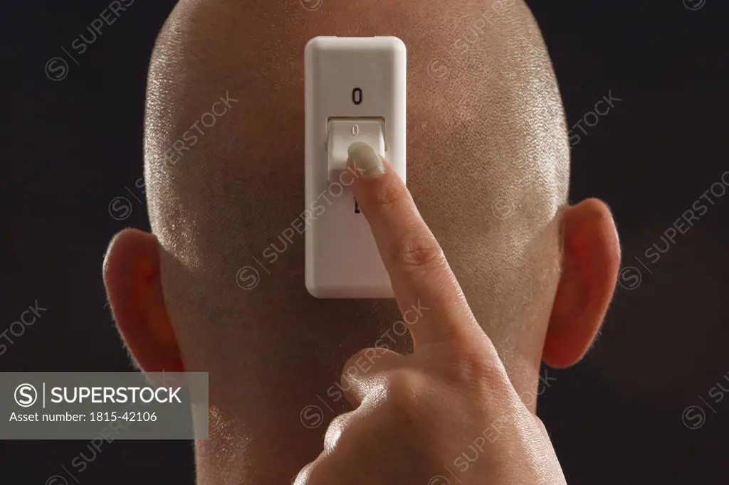 Man with rocker switch on back of head