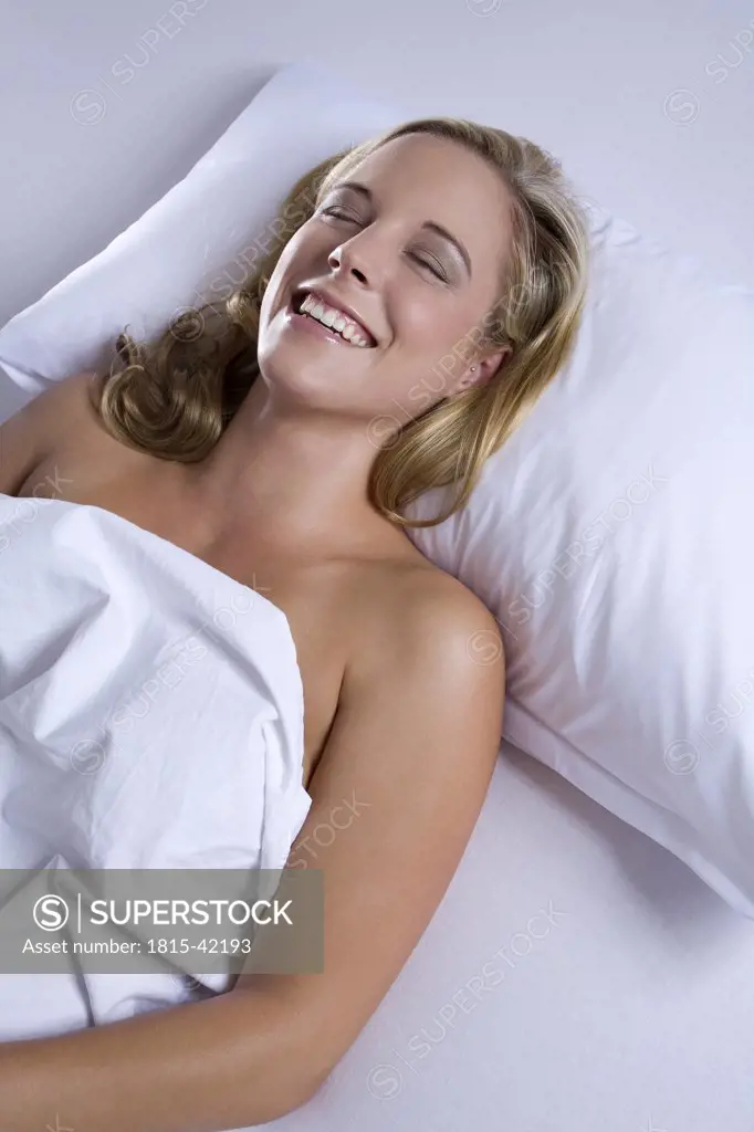 Young blonde woman lying on bed, portrait