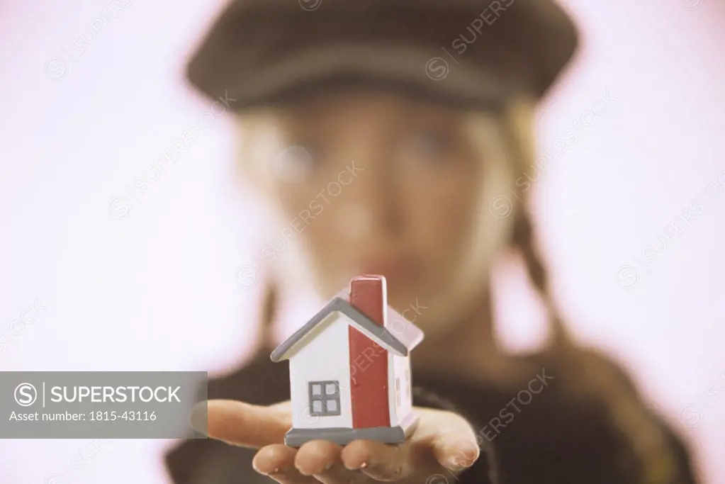 Young woman with toy house in her hand