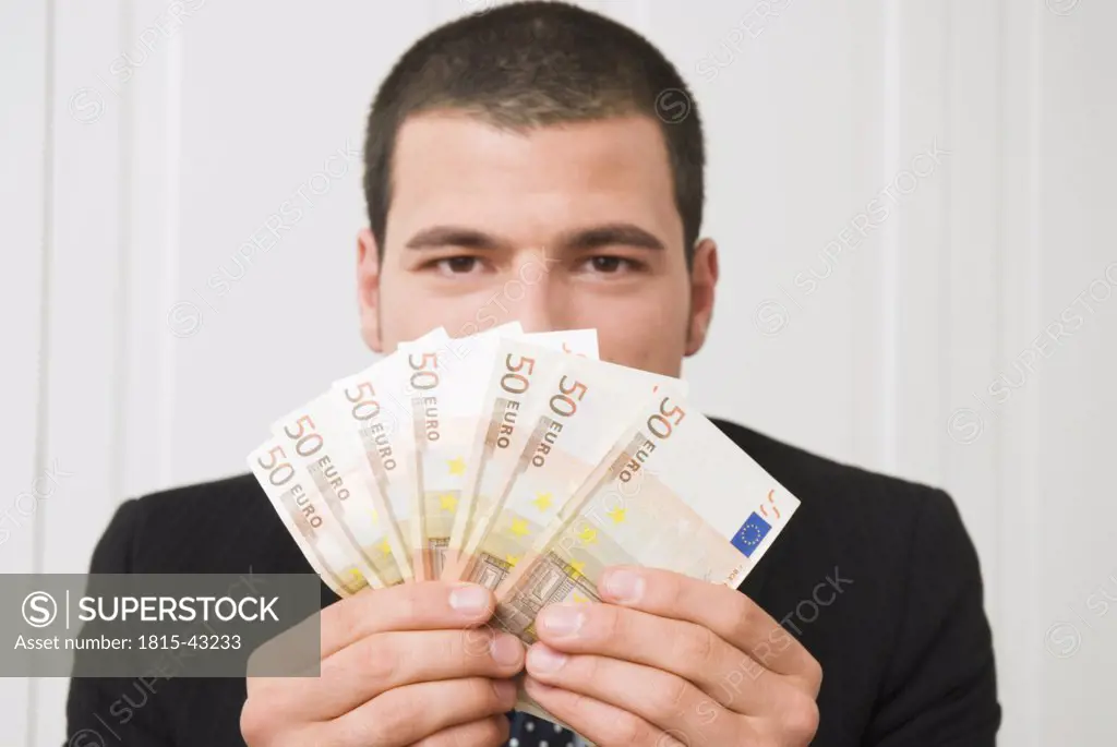 Young man holding euro banknotes, portrait