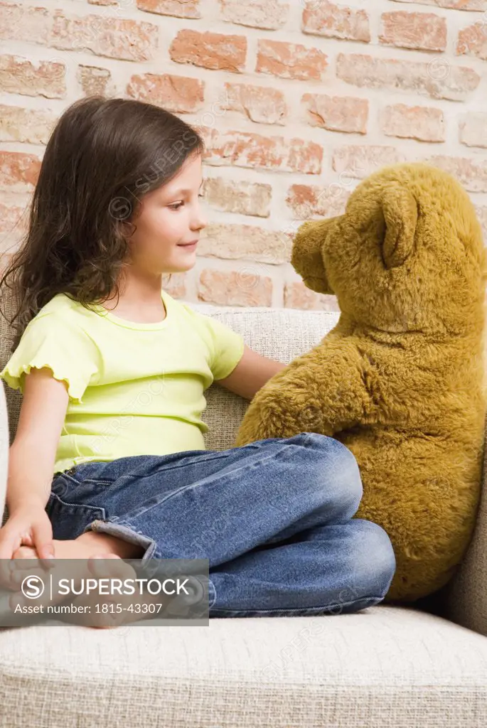 Young Girl (8-9) playing with teddy bear, portrait