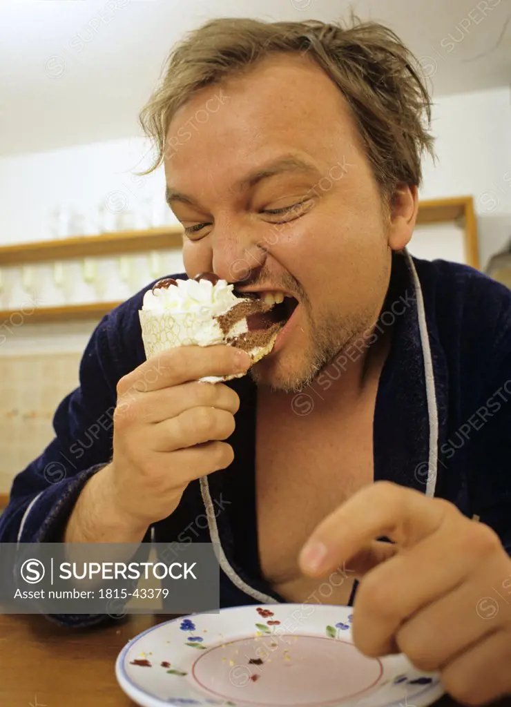 man devouring a piece of cake
