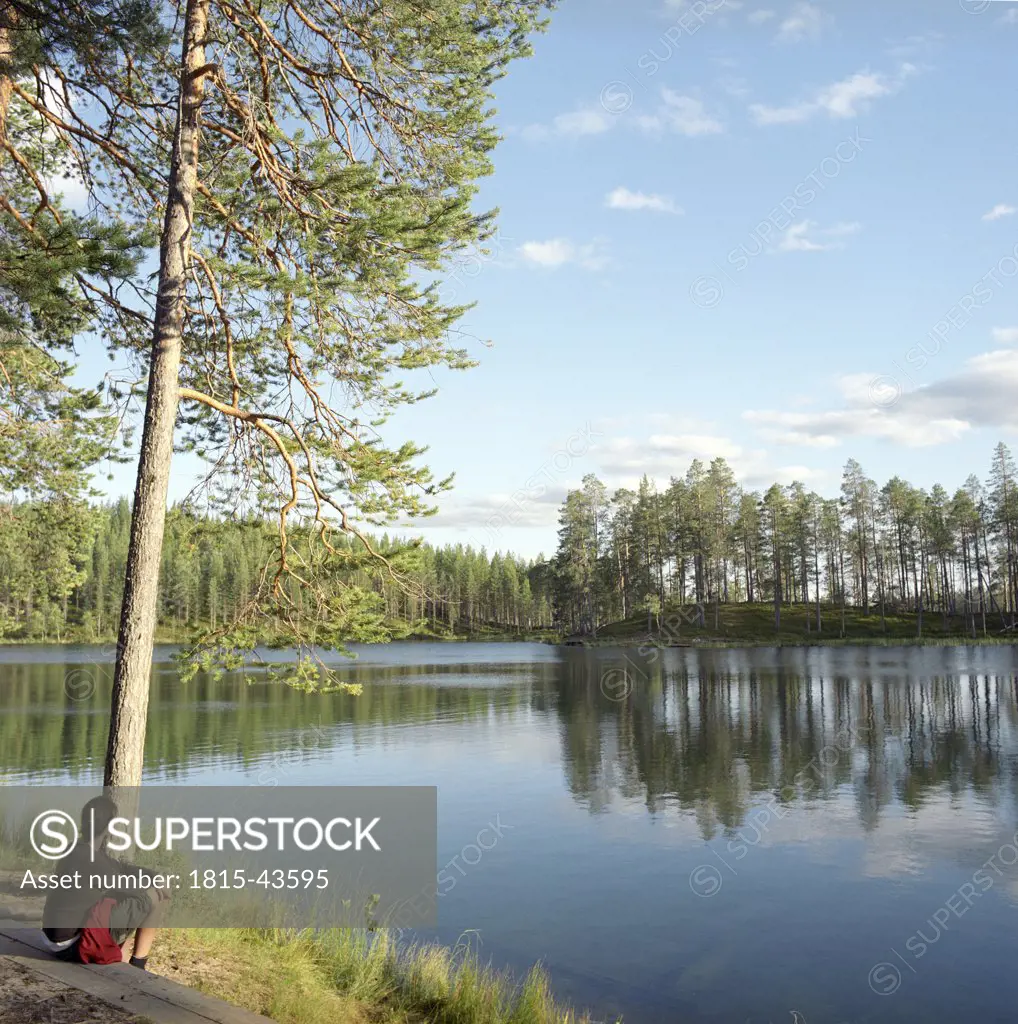 Finland, Hossa National Park, woman on lakeside