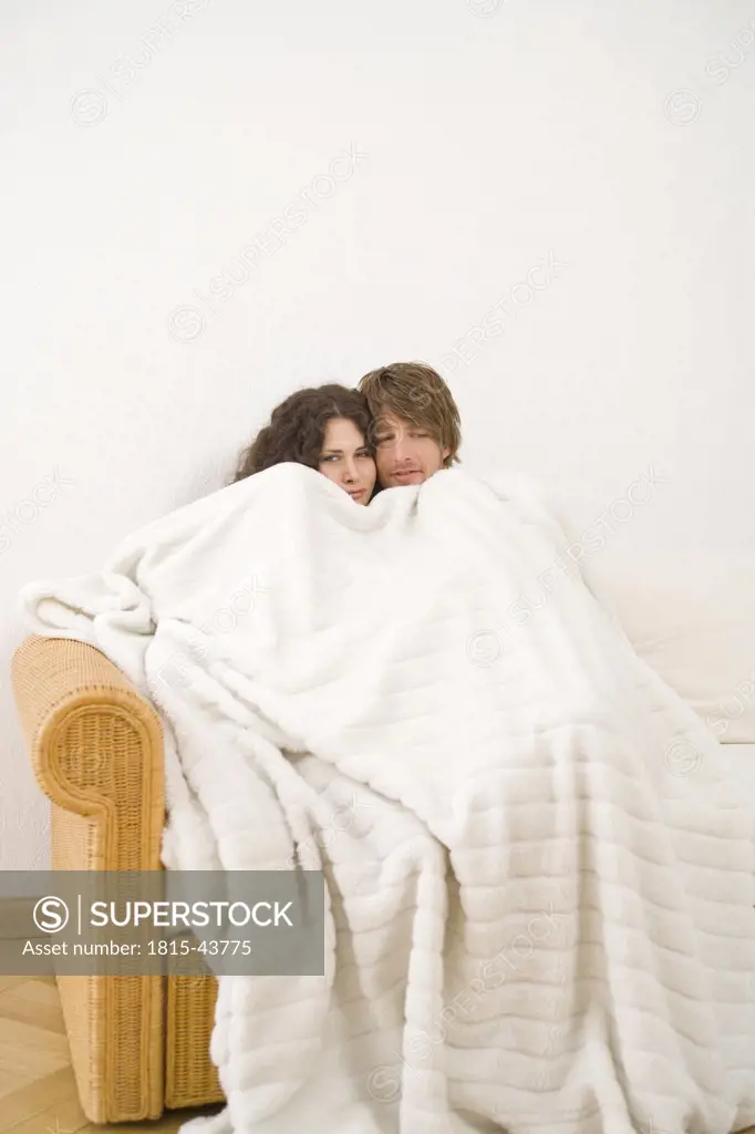 Young couple under blanket