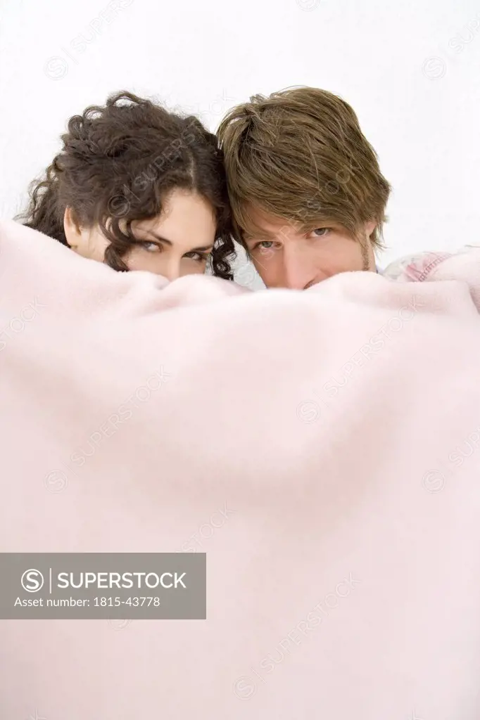Young couple under blanket
