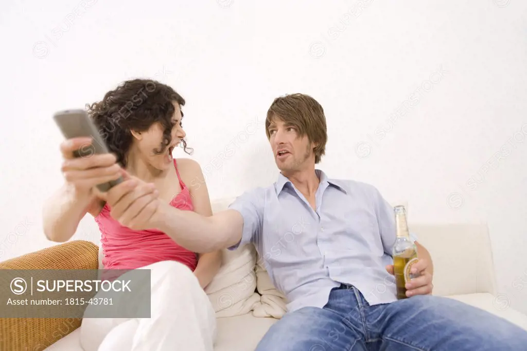 Young couple fighting over the remote control