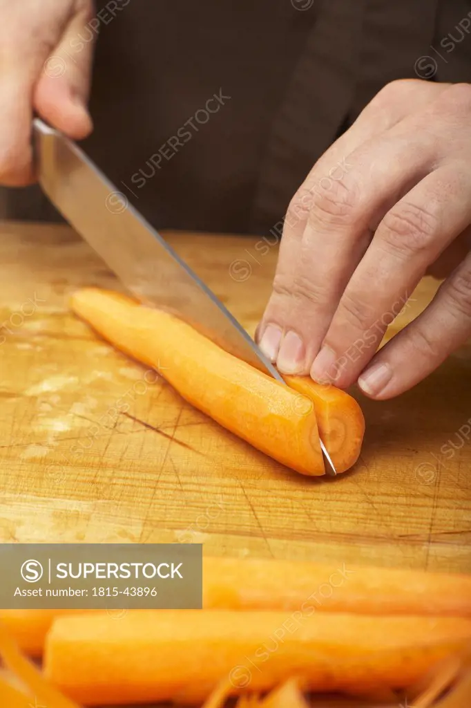 Cutting carrot in half, crosswise, close-up