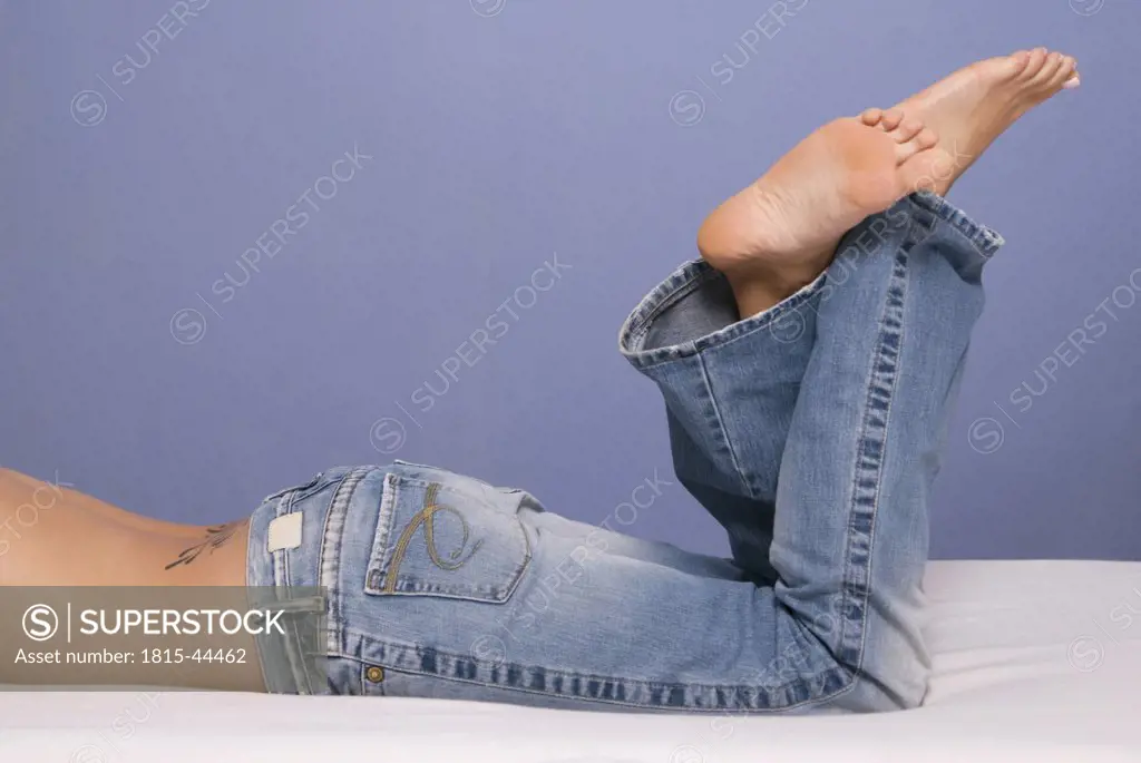 Woman on bed wearing jeans