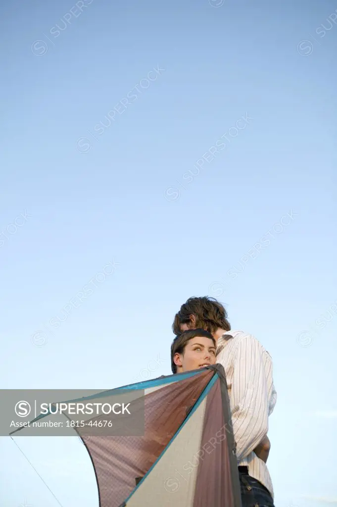 Young couple embracing, holding kite