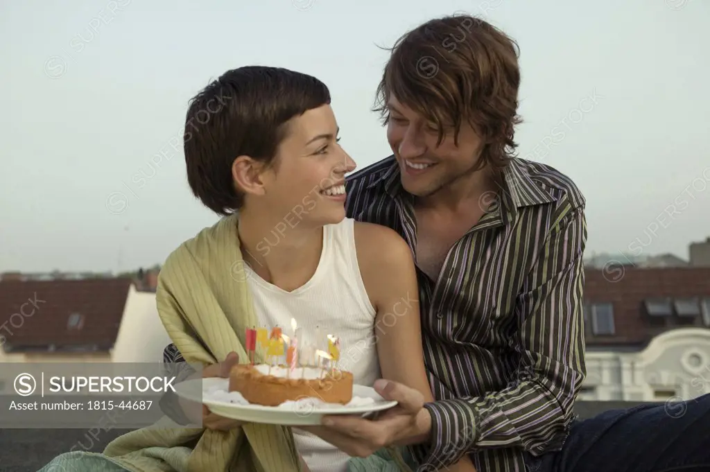 Man giving birthday cake to woman