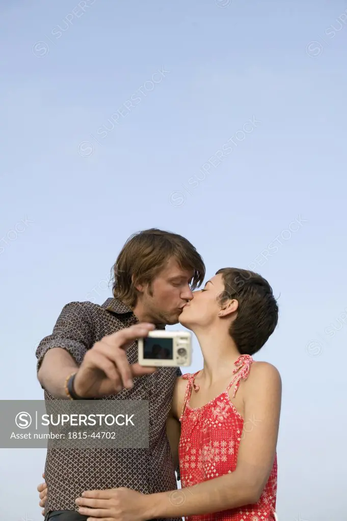 Young couple taking photograph of self