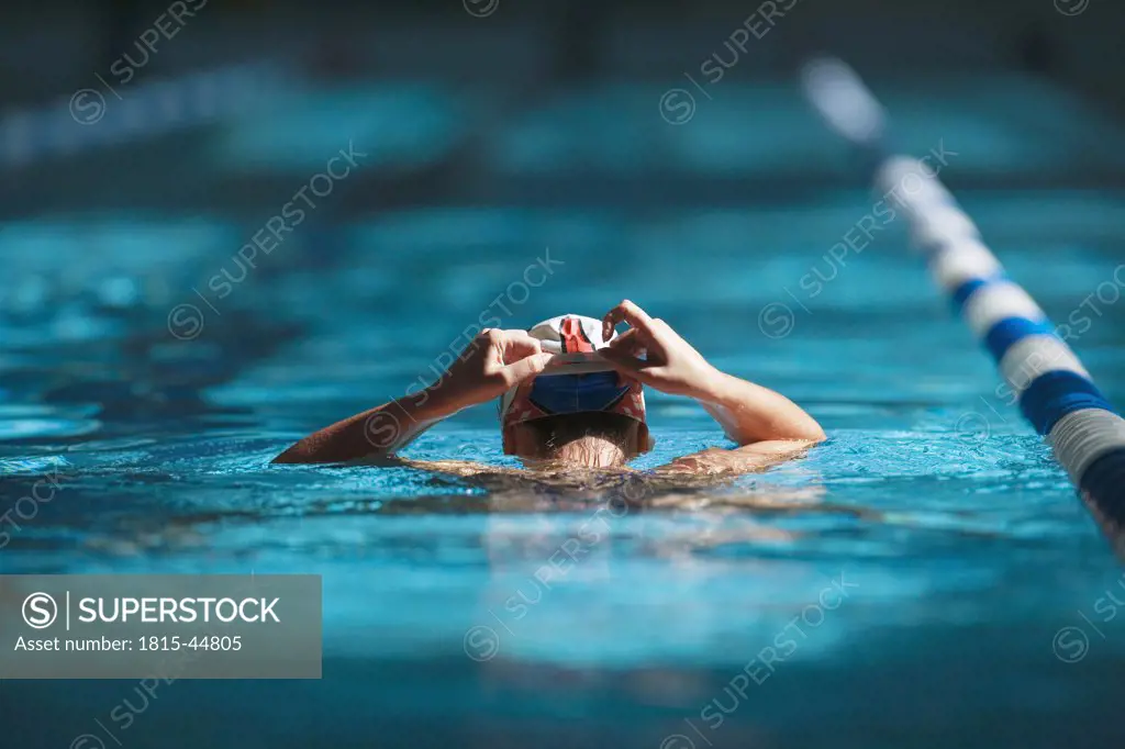 Swimmer adjusting bathng cap