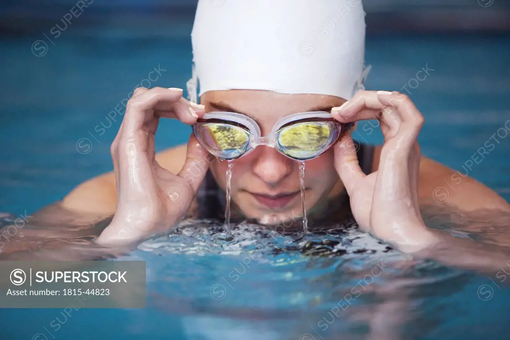 Female swimmer emptying goggles