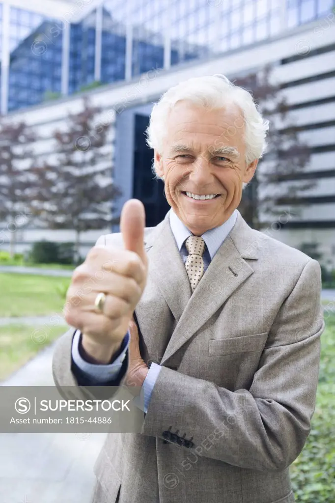 Germany, Baden Württemberg, Stuttgart, Senior businessman with thumbs up sign, smiling, portrait