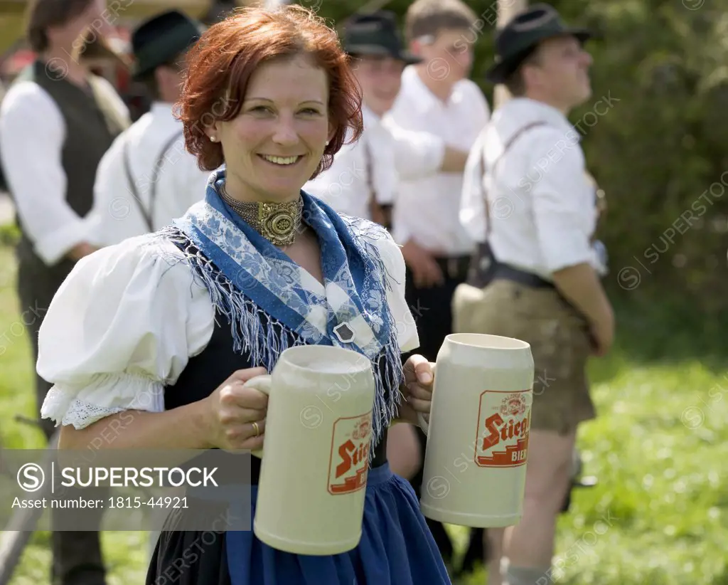Young woman carrying beer steins