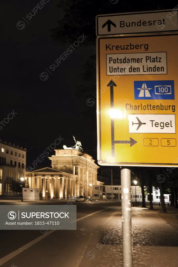 Germany, Berlin, Brandenburger Tor at night, road sign in foreground