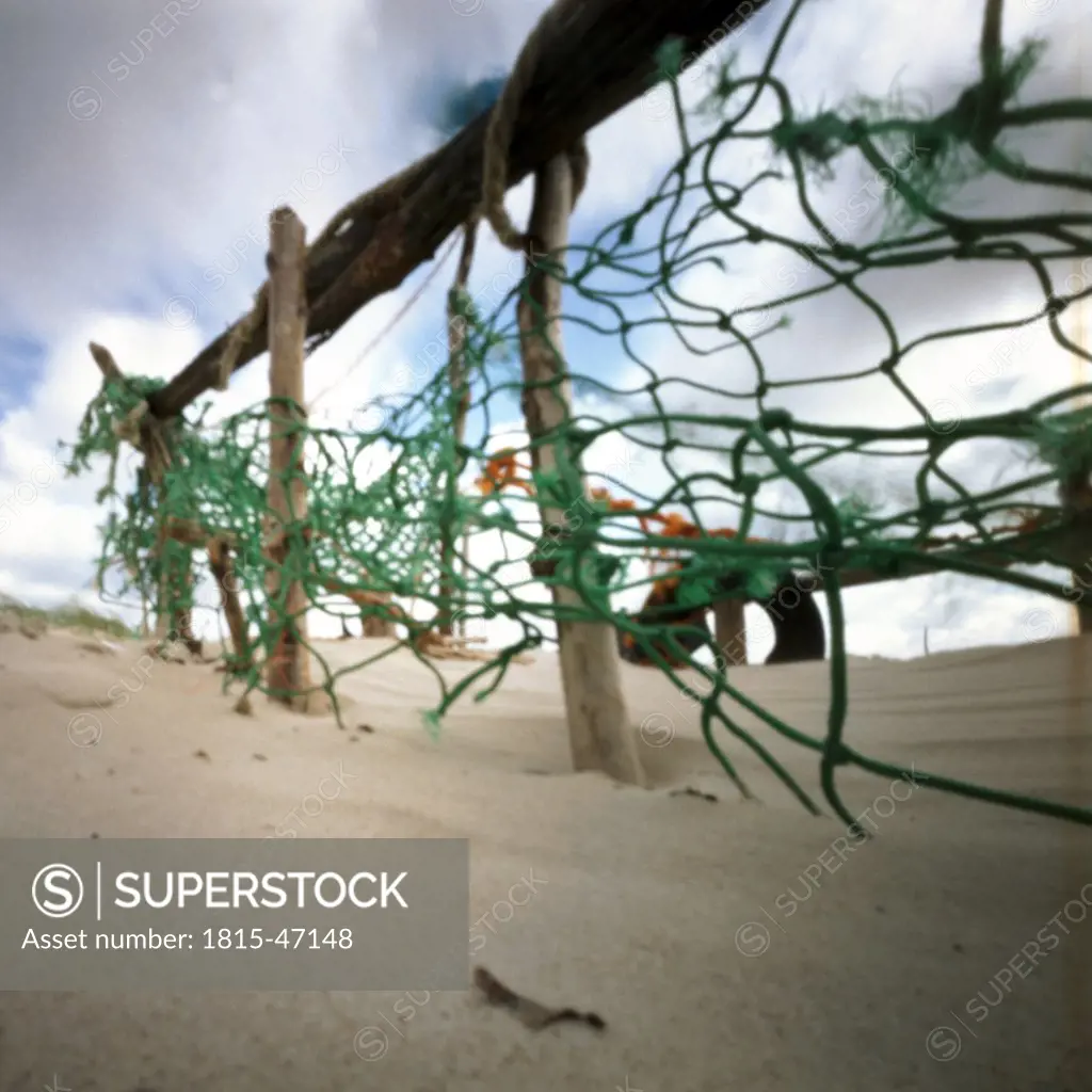 Germany, North Sea, Amrum, Tattered fishing net on the beach