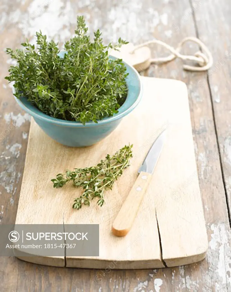 Thyme in bowl, knife and chopping board