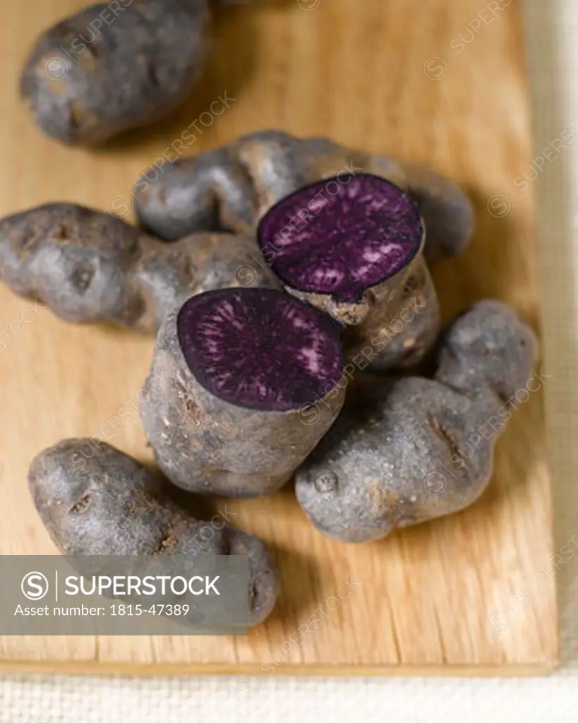 Truffle de Chine blue-violet potatoes on chopping board, elevated view