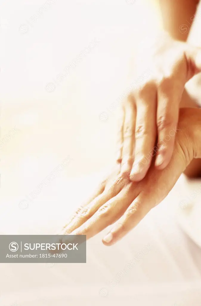 Woman applying moisturizer to hand
