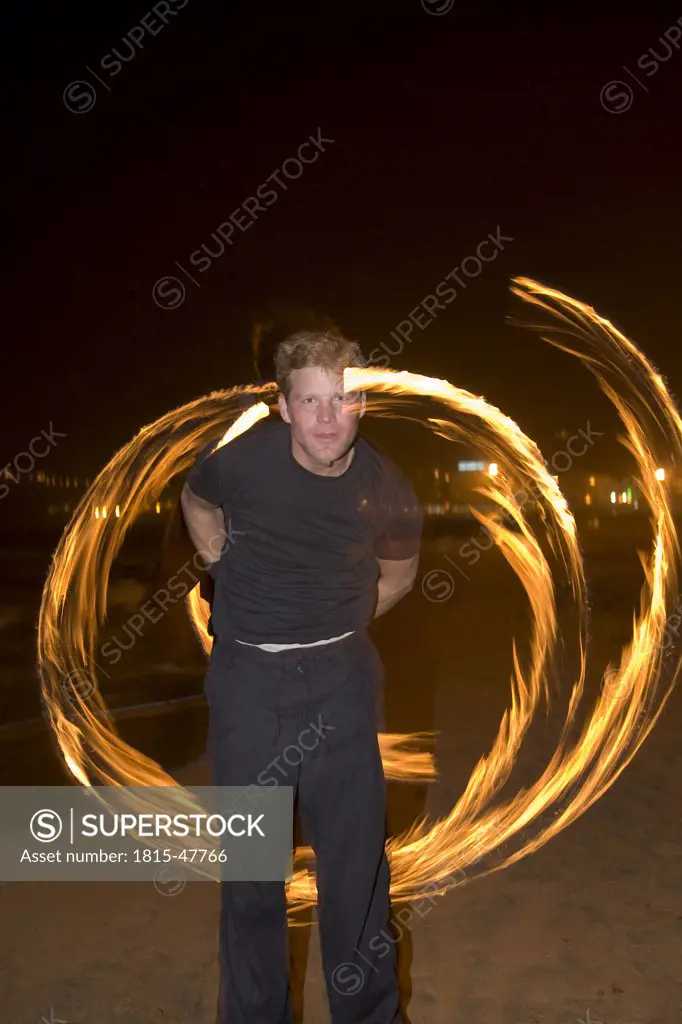Spain, Canary Islands, Gran Canaria, Young man juggling with torches
