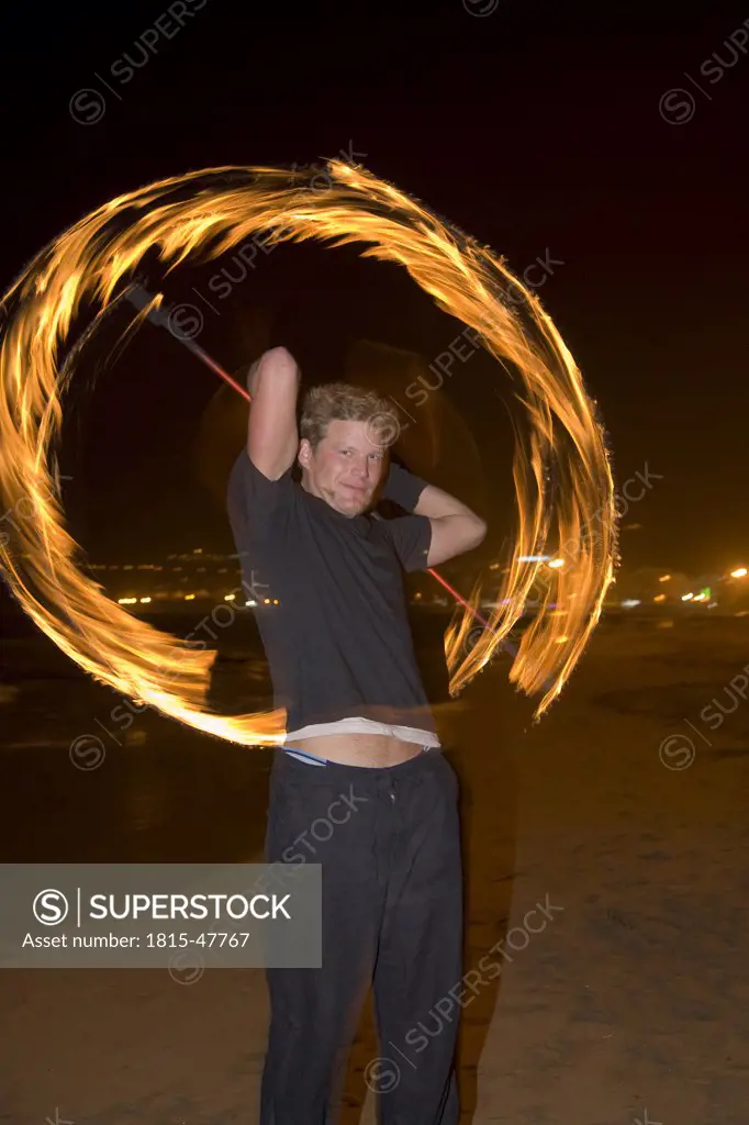Spain, Canary Islands, Gran Canaria, Young man juggling with torches