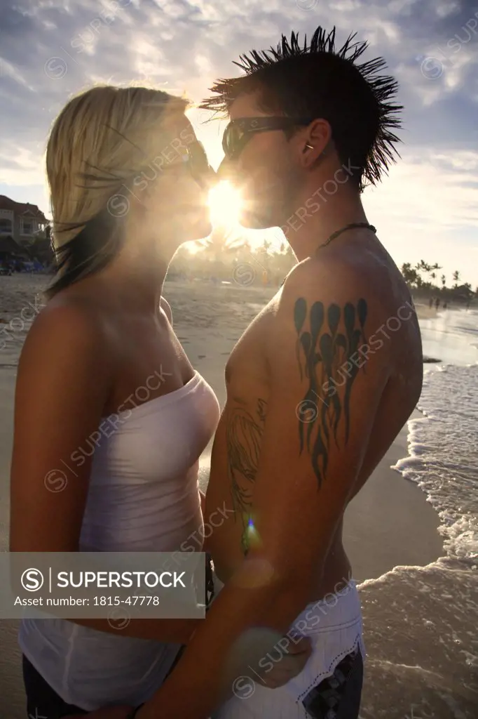 Dominican Republic, Young couple on beach kissing, portrait