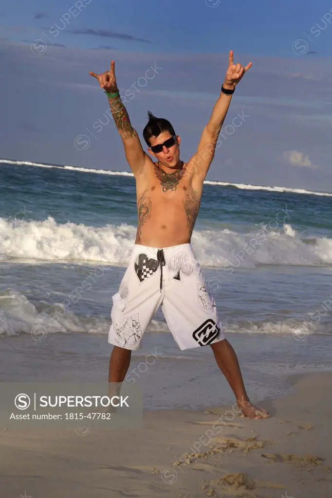 Dominican Republic, Young man on beach, ""arms up"" portrait