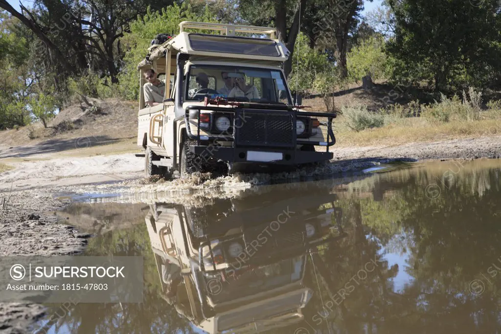 Africa, Botswana, Okavango Delta,Vehicle crossing waterhole