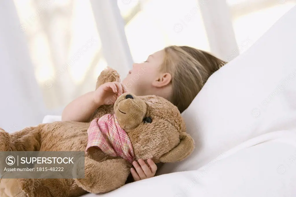 Little girl (3-4) playing with teddy bear