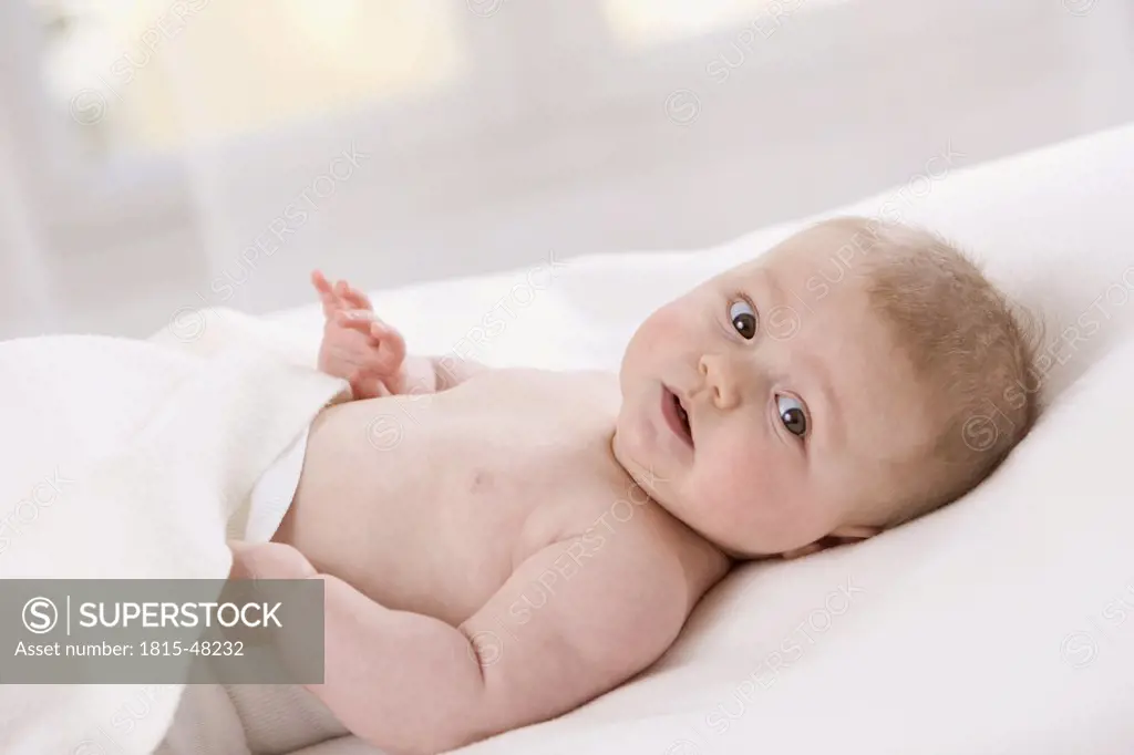 Baby girl (7 months) lying on back, portrait