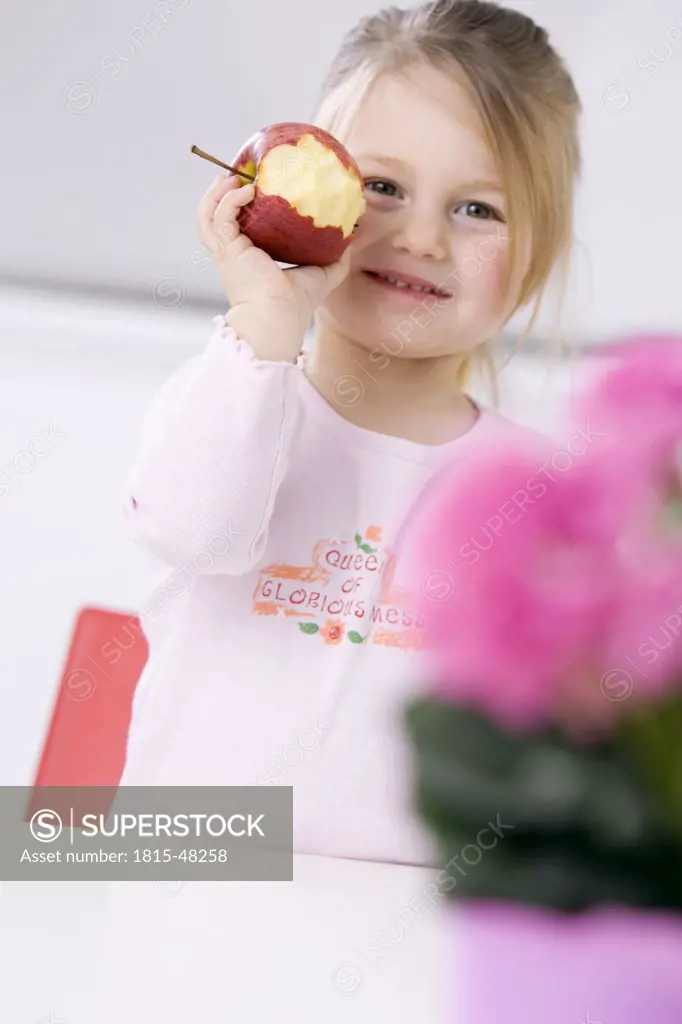 Little girl (3-4) holding an apple, portrait