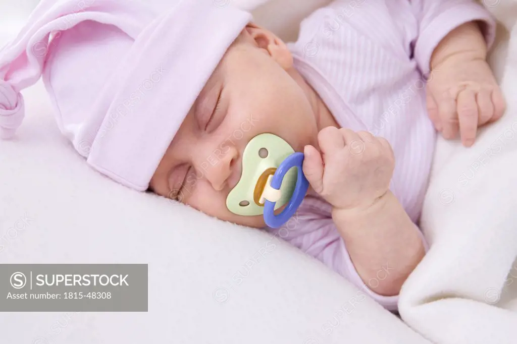 Baby girl (2 months) sleeping with pacifier, portrait