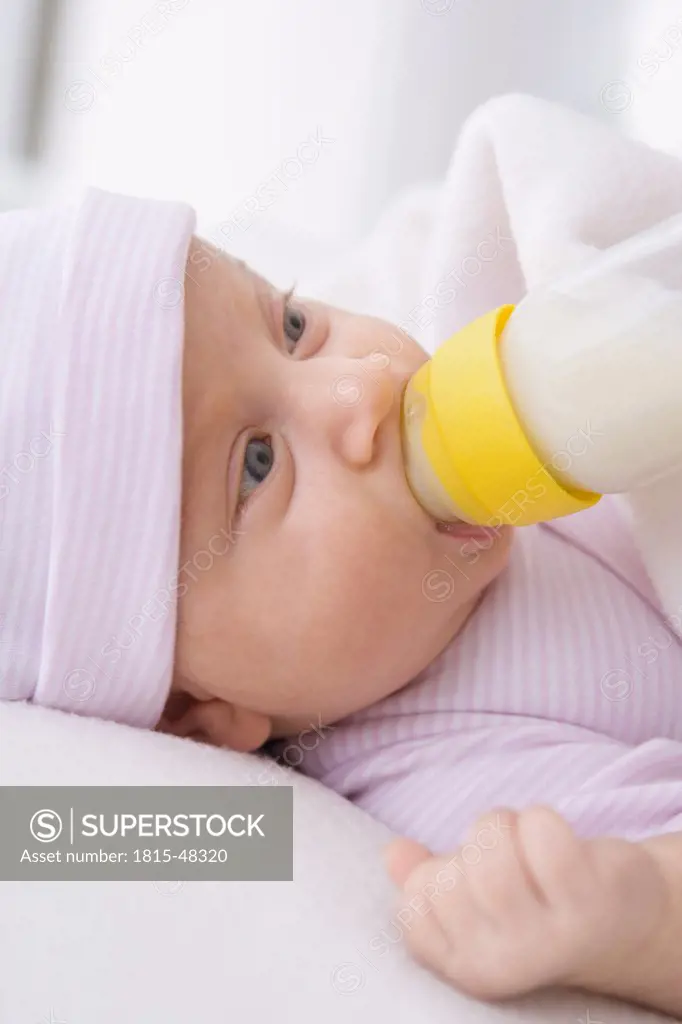 Baby girl (2 months) being fed by bottle, portrait