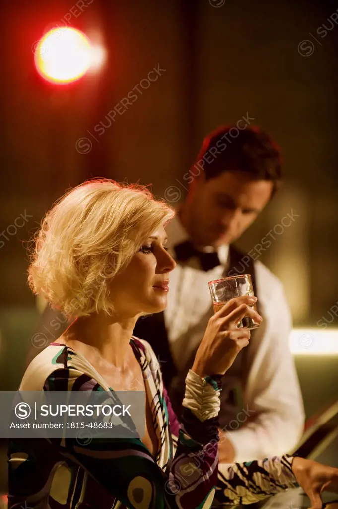 Young woman in bar, Barkeeper in background