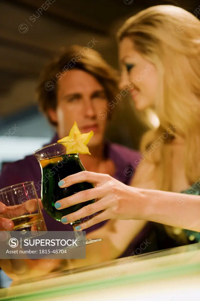 Young couple toasting at bar