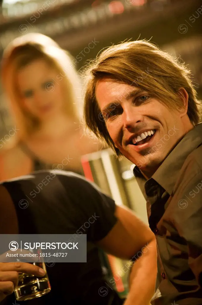 Two men in bar, smiling, portrait