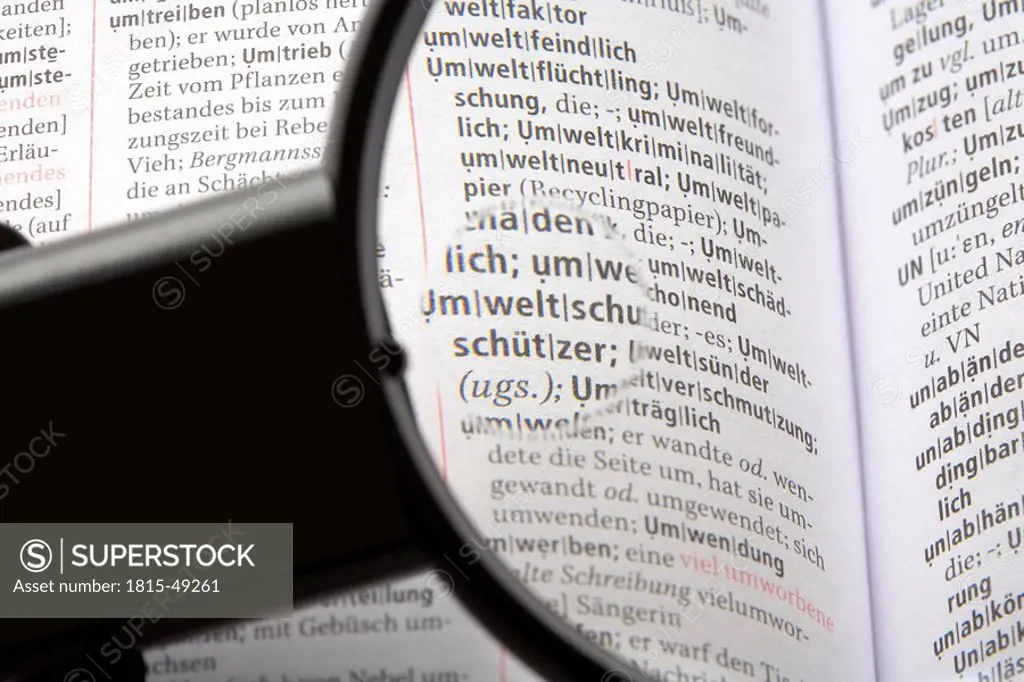 Magnifying glass on encyclopedia, close_up